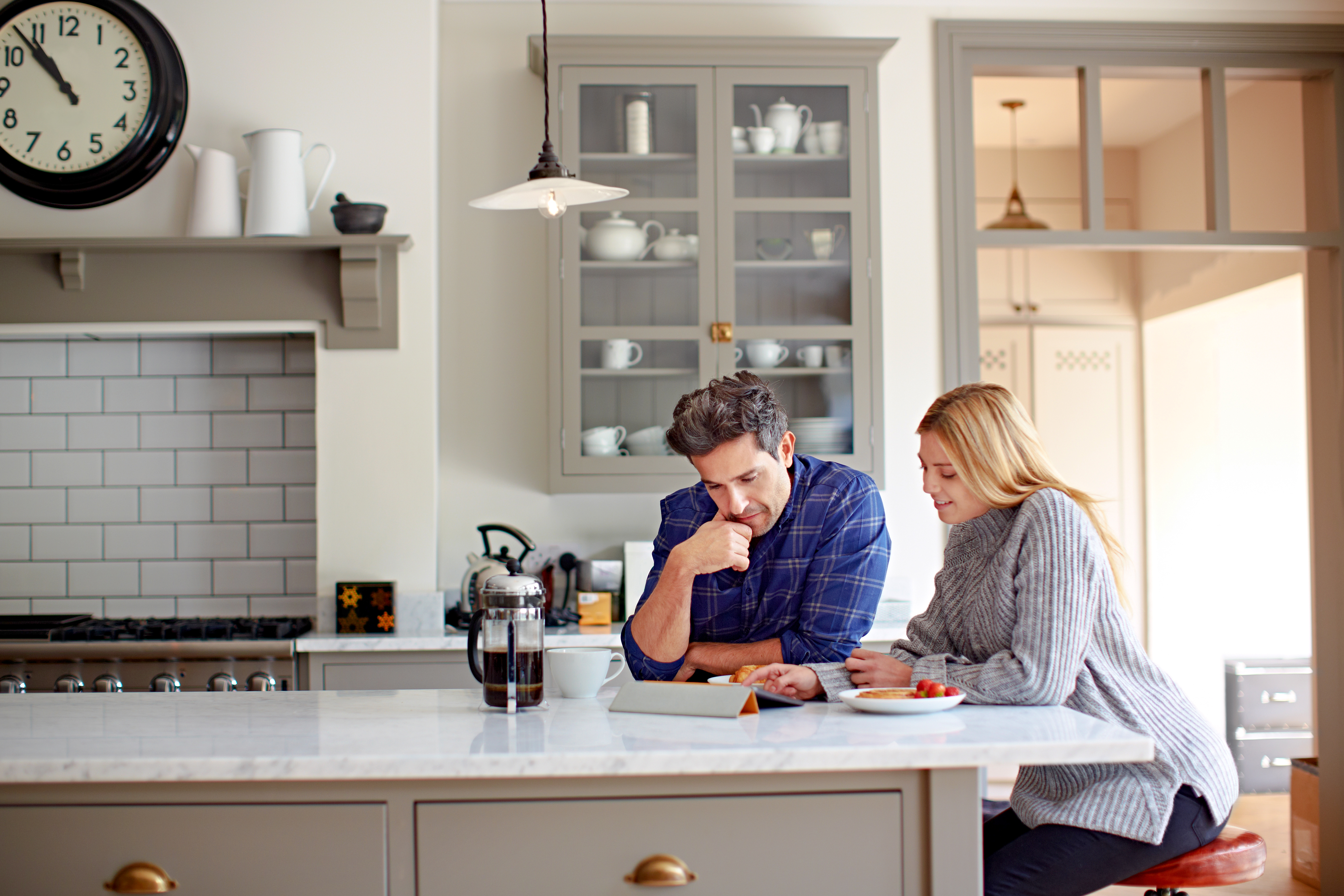 Two people sitting at the kitchen island reviewing information relating to the most commonly asked mortgage questions. 
